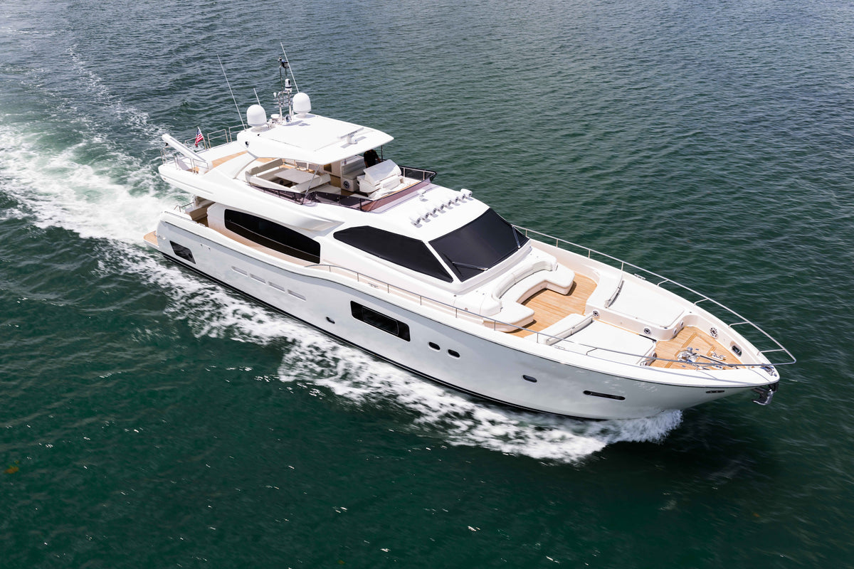 White motor yacht cruising on blue-green water, viewed from above