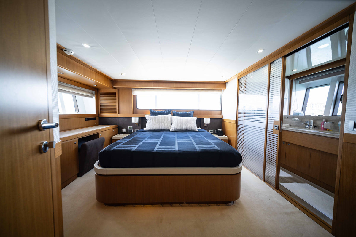 Wood-paneled cabin with a double bed and dark blue bedding