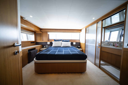 Wood-paneled cabin with a double bed and dark blue bedding