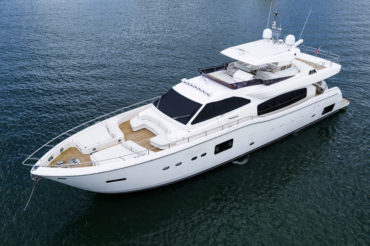 Three-quarter exterior view of the yacht at anchor with the bow lounge and flybridge visible