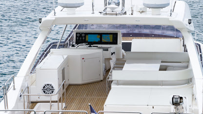 Elevated view into the flybridge with white lounge seating and the helm