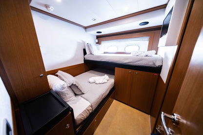 Wood-paneled cabin with two offset bunk beds and neatly folded towels