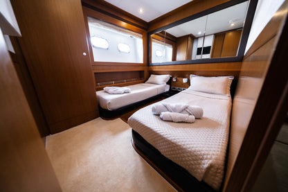 Twin cabin with two single beds, white linens, and warm wood cabinetry