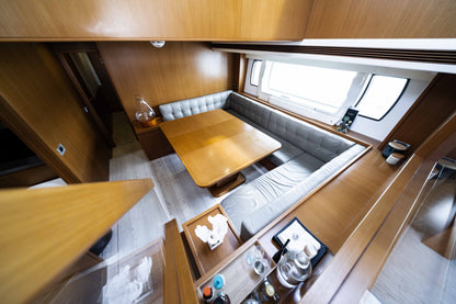 Interior dining nook with a U-shaped upholstered bench and a wooden table beside a window